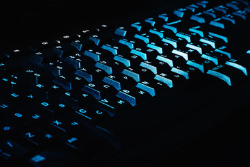 Obraz premium Black keyboard with Russian layout illuminated by blue light 
