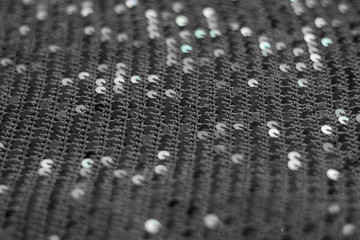 Texture of knitted fabric with sequins. Black and white texture