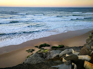 embankment of the ocean at golden hours of sunset, dawn. A staircase descends down to the sand and...