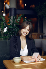 Woman working with a notebook. Lady with a coffee. Businesswoman use the phone