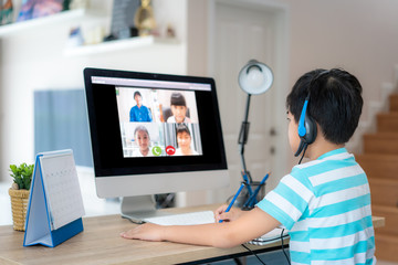 Asian boy student video conference e-learning with teacher and classmates on computer in living...