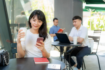 Asian young man and woman sitting one person per one table for distance of 6 feet distance protect from COVID-19 viruses for social distancing for infection risk at coffee cafe..