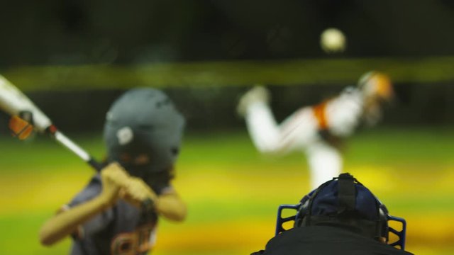 Shot from behind umpire of pitcher throwing a strike at baseball game