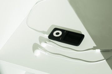 MP3 negro conectado a unos auriculares blancos. 