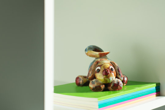 Libros con un perro de cerámica de pisapapeles. 