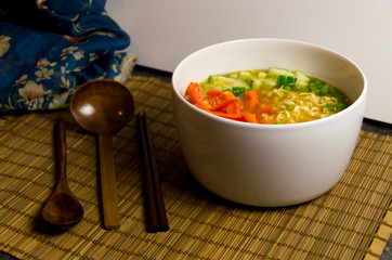 Vegan Japanese Ramen Noodle Soup with red bell pepper and cucumber served in a white bowl with...