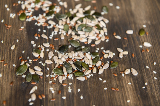 Seed of flax, sunflower, pumpkin, sesame seeds on a wooden background. Top view. Photo taken with selective focus.