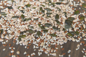 Seed of flax, sunflower, pumpkin, sesame seeds on a wooden background. Top view. Photo taken with selective focus.