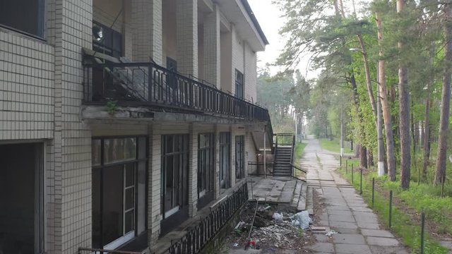 Abandoned building exterior with broken windows. Aerial side view