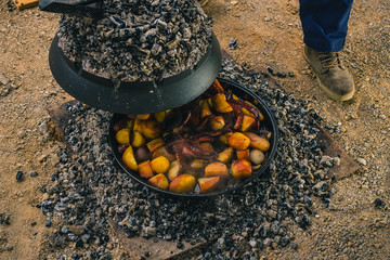 Cooking traditional balkan turkish bosnian dalmatian meal Peka in metal pots called sac sach or...