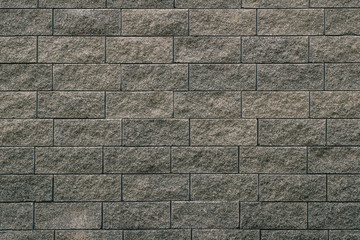 Gray grey tiled stone wall with sharp edges. Texture of a grey tiled wall.