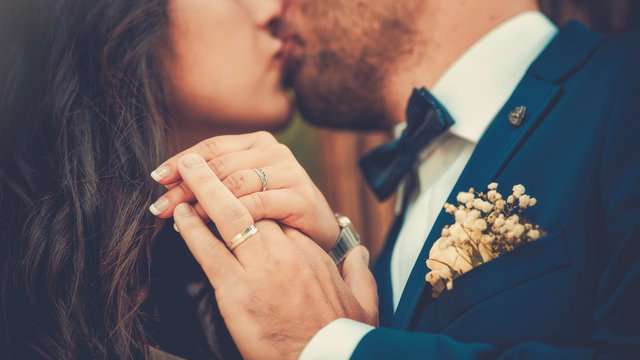 Alliances de mariage. Mari&eacute;s qui s'embrassent. Mains du couple qui s'embrasse. C&eacute;l&eacute;bration de l'amour lors d'un mariage luxueux