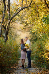 couple on autumn walk outdoors. Two lovers in autumn park. Love and tender touch. Romantic date in autumn park. Family couple enjoing of each other. Gentle tender hugs. Happy man and woman pair