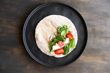 Whole tortilla with spinach, mozzarella, cherry tomatoes and chopped chicken.