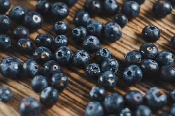 Fresh juicy blueberries on wooden board. Close up