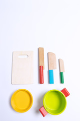 Fototapeta premium Sets of wooden knife toys, chopping board and sets of pots on top of white background