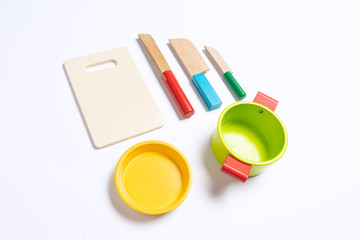 Sets of wooden knife toys, chopping board and sets of pots on top of white background