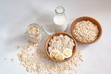 ingredients for making oatmeal porridge on a white background