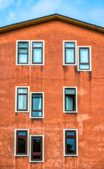 Obraz premium An orange apartment building in Verona Italy with windows in odd placements 