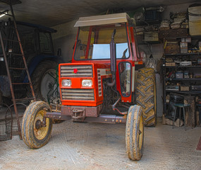 A very old well kept red tractor in a barn in Friuli Italy