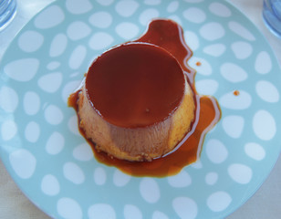 creme caramel on polka dot blue plate