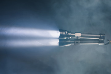 ray of pocket flashlight in smoke, copy-space background