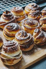 Cinnamon rolls sprinkled with powdered sugar on a wooden Board