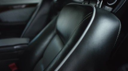 Close-up view in interior leather salon of prestige modern car. Black leather driver seat in close shot