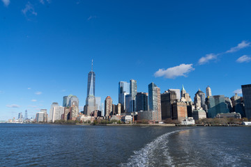 view of Manhattan New York from the hudson river and boat heading to statue of liberty - obrazy, fototapety, plakaty
