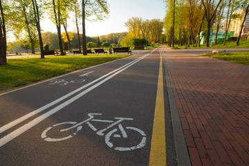 Empty bike path route infrastructure early in the spring sunny morning. No people in the park,...