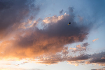 An airplane flying close to the ground during a sunset. 