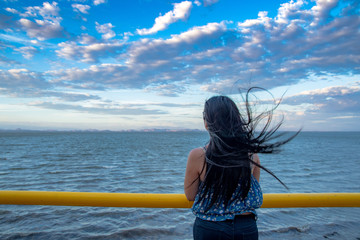 Girl looking out a the sea on the coast of El Salvador