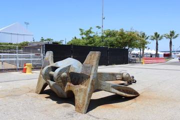 Old rusty anchor decorating the outside, with a blue background with trees on it