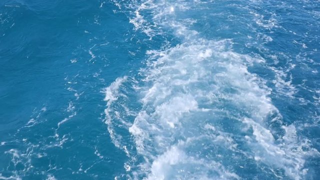 Strong Waves Rise at the Water From the Motion of the Yacht. A Blue Plume and White Splashes Appeared Cause of a Moving Motorboat. Water in the Sea is Crystal Blue.