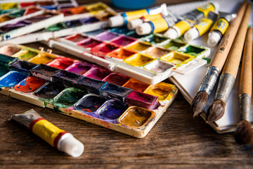 Old school watercolor paints and brushes for watercolor. Watercolors in tubes and in plastic boxes.