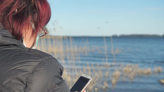 The view of the sea with the lady looking at her phone