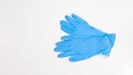 Blue latex medical gloves on white table. Top down with copy space on left.