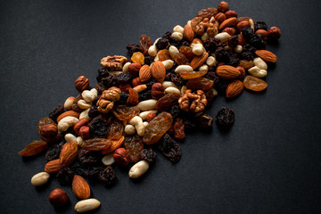 Nuts and dried fruits on a black background. Useful food for weight loss and diet. Background. Horizontal photo in good quality.