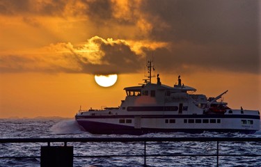 Obraz na płótnie Canvas Side View Of Ship In Calm Sea At Sunset