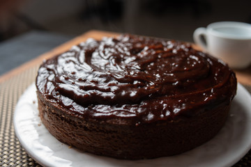 
Homemade chocolate cake in porcelain plate on wooden table