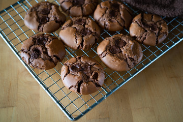 soft dark chocolate brownie cookies on a metal rack on a wooden background.