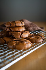 soft dark chocolate brownie cookies on a metal rack on a wooden background.