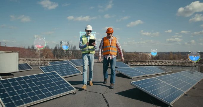 Workers checking solar panels on rooftop