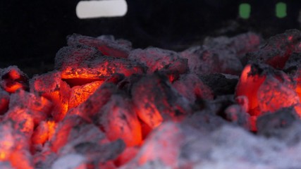 Close view at a glowing charcoal and flame in the barbecue grill. Shallow DOF.
