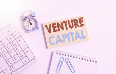 Writing note showing Venture Capital. Business concept for financing provided by firms to small early stage ones Keyboard with empty note paper and pencil white background