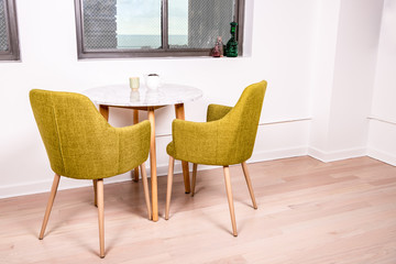  A tea cup and tea pot on a table in a modern home, by a window with a beautiful view. Breakfast nook.