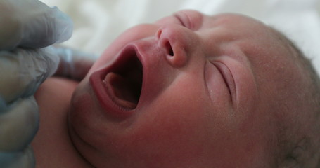  Infant newborn baby crying after birth, first seconds of life