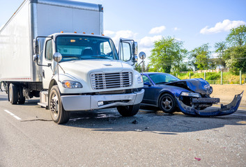 Road accident with damage to vehicles as a result of a collision between a semi truck with box trailer and a car - obrazy, fototapety, plakaty