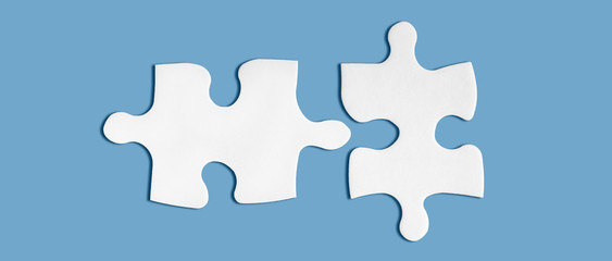 Pair of two matching puzzle pieces isolated on blue background. Successful decision, solution of...