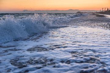 Waves from the sea at a beach in sunset